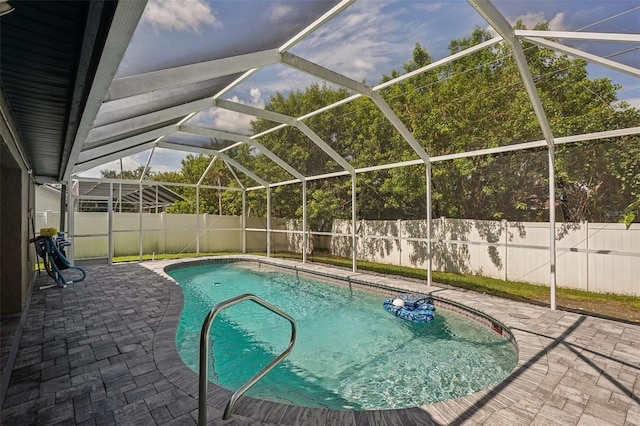 view of swimming pool featuring glass enclosure and a patio area