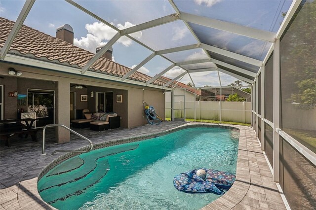 view of pool featuring outdoor lounge area, a patio, and a lanai