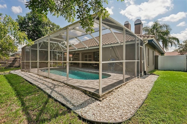 view of swimming pool featuring a yard and a lanai