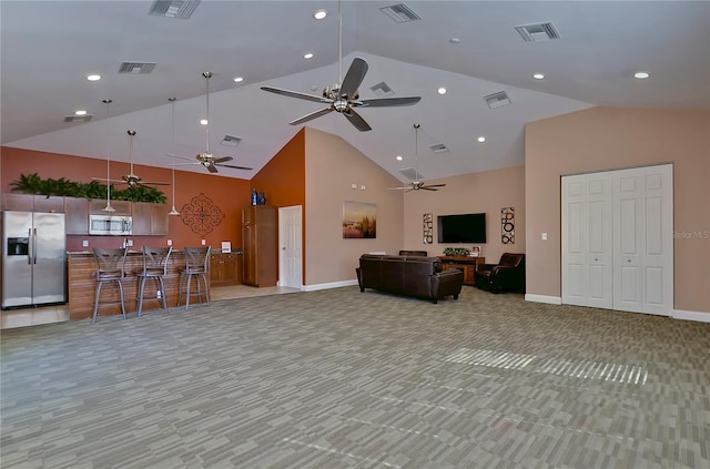 carpeted living room with high vaulted ceiling