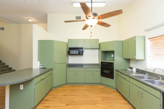 kitchen featuring ceiling fan, light wood-type flooring, sink, black appliances, and green cabinets