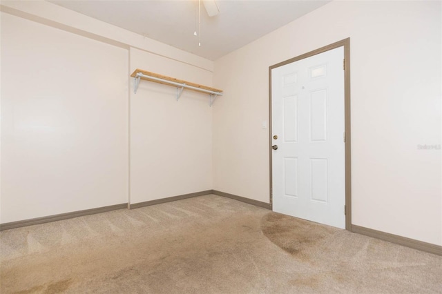 unfurnished room featuring ceiling fan and light colored carpet