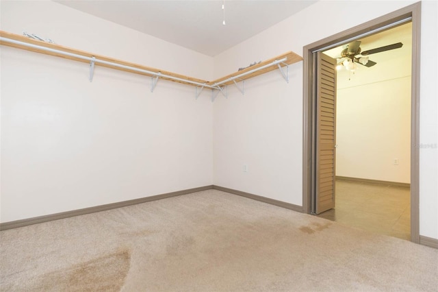 spacious closet with light carpet and ceiling fan