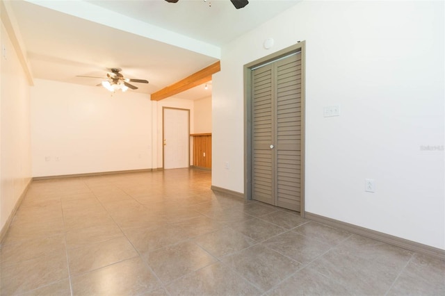 tiled spare room with ceiling fan and beamed ceiling