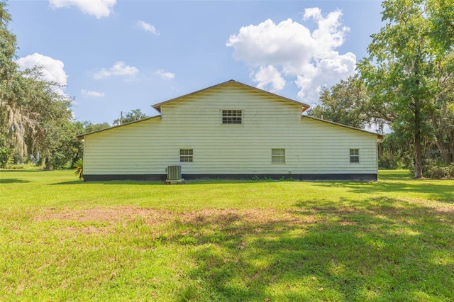 view of home's exterior with a lawn and central AC unit