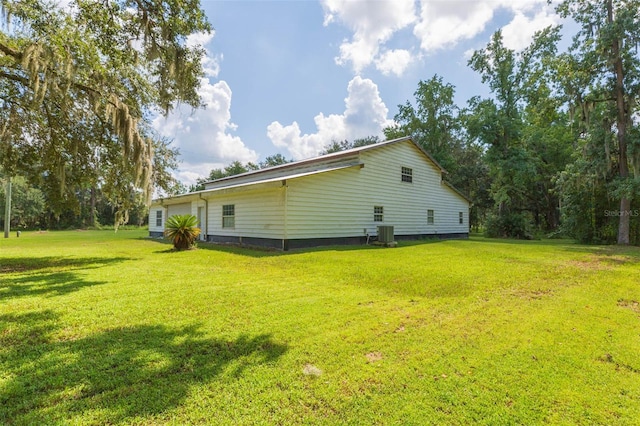 view of side of home featuring a lawn and central AC