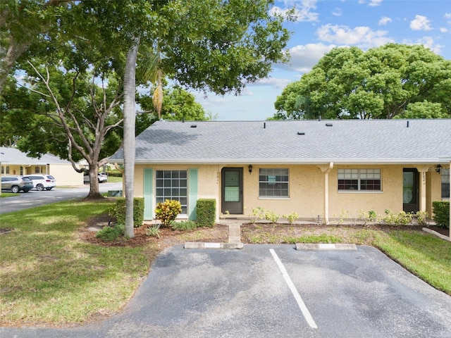 single story home featuring a front lawn