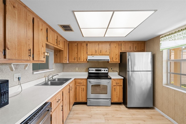 kitchen featuring sink, exhaust hood, stainless steel appliances, and light hardwood / wood-style flooring