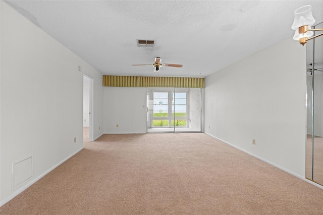 carpeted empty room featuring ceiling fan and a textured ceiling