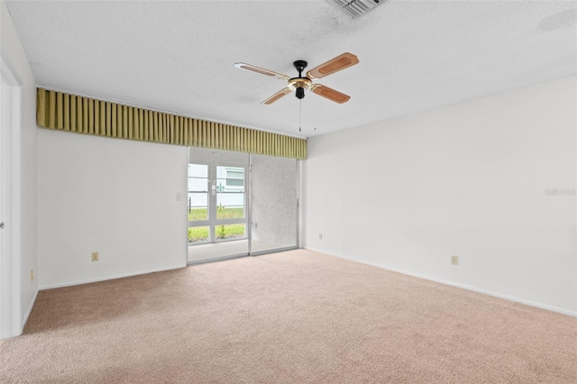 unfurnished room with ceiling fan, carpet, and a textured ceiling