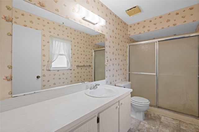 bathroom with walk in shower, vanity, and toilet