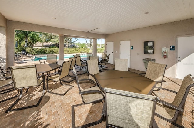 exterior space featuring outdoor dining space and a fenced in pool