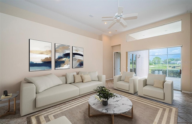 living area with baseboards and ceiling fan