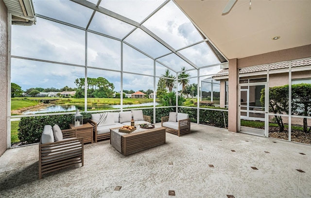 sunroom / solarium with ceiling fan and a water view