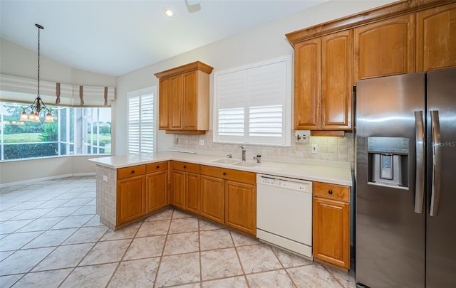 kitchen with a sink, backsplash, white dishwasher, stainless steel fridge with ice dispenser, and vaulted ceiling