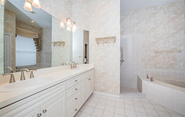 full bath with a sink, a bath, tile patterned flooring, and wallpapered walls