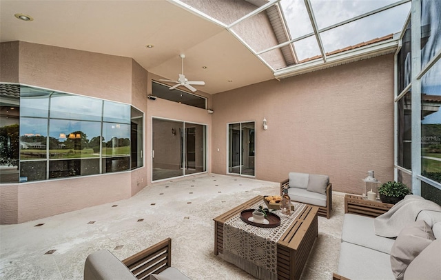 view of patio with glass enclosure, an outdoor hangout area, and a ceiling fan