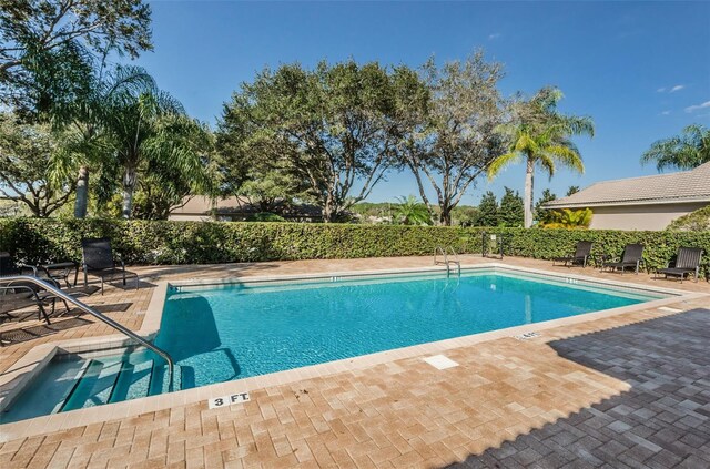 pool with a patio area and fence