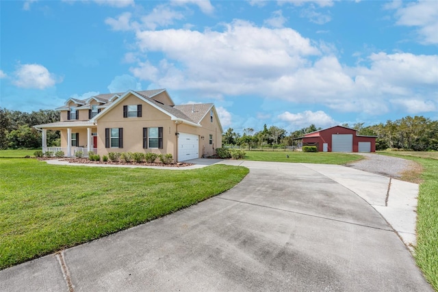 view of front facade with concrete driveway, a front lawn, an outbuilding, and stucco siding