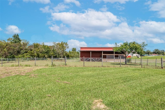 view of yard featuring an exterior structure, an outbuilding, and a rural view