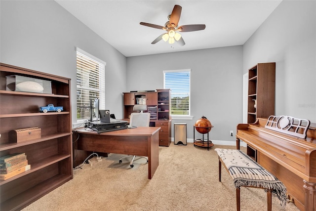 office area with a ceiling fan, baseboards, and carpet