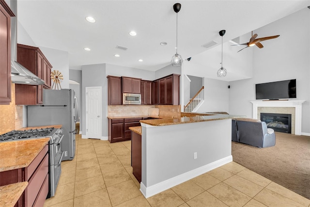 kitchen with wall chimney range hood, light tile patterned floors, appliances with stainless steel finishes, open floor plan, and ceiling fan