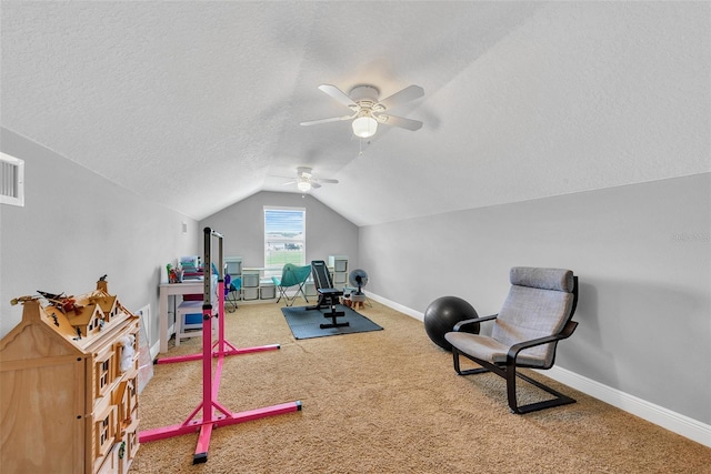 workout area featuring lofted ceiling, a ceiling fan, carpet, and a textured ceiling