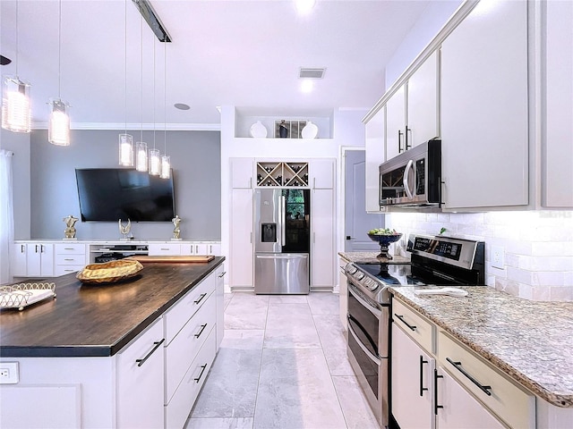 kitchen featuring tasteful backsplash, white cabinets, stainless steel appliances, a center island, and decorative light fixtures