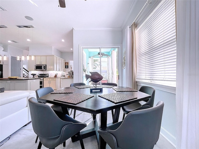 dining area with ornamental molding and ceiling fan