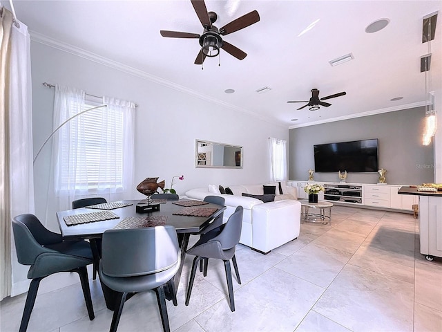 tiled dining room featuring crown molding and ceiling fan