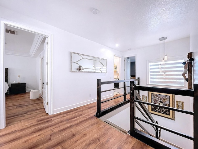 corridor with hardwood / wood-style flooring and a textured ceiling