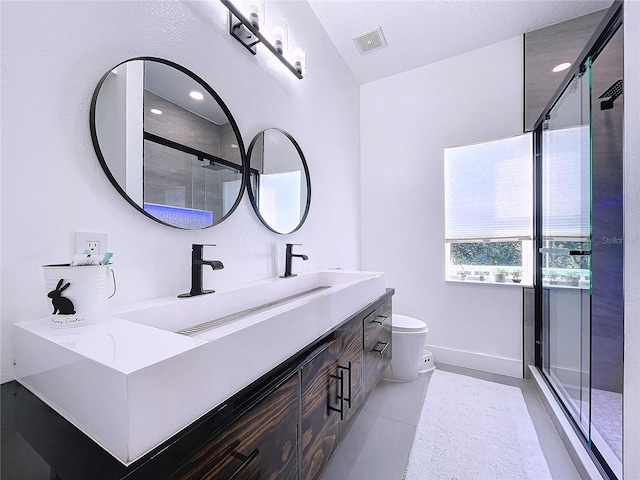 bathroom featuring vanity, toilet, an enclosed shower, and tile patterned floors