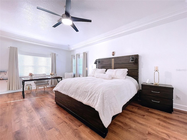 bedroom featuring ceiling fan, a textured ceiling, crown molding, and hardwood / wood-style floors