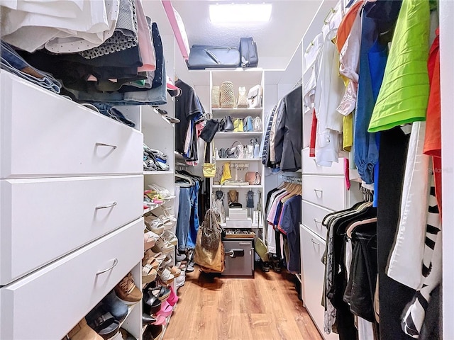 walk in closet with light wood-type flooring