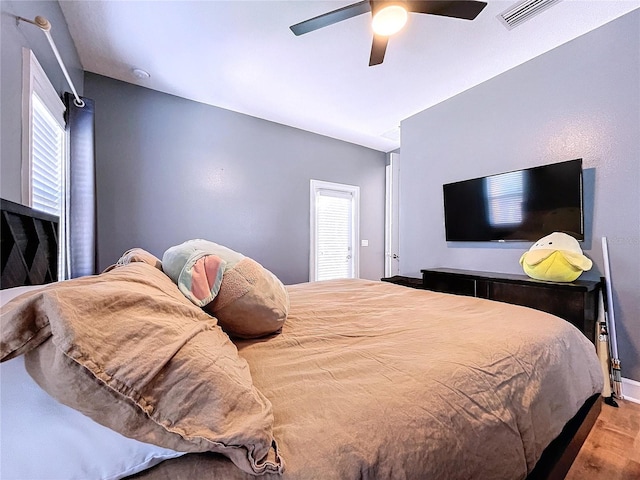 bedroom with light wood-type flooring, ceiling fan, and multiple windows