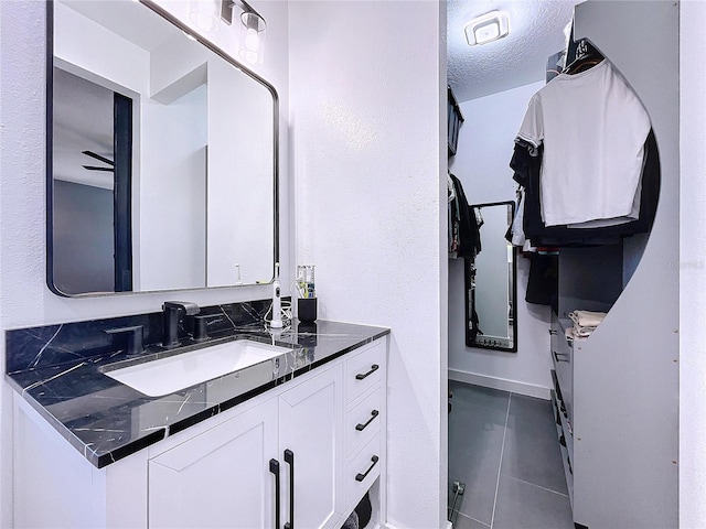 bathroom featuring a textured ceiling, vanity, and tile patterned floors