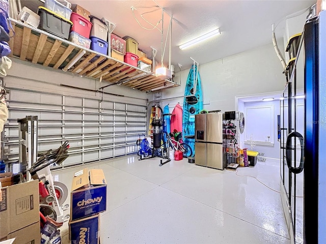 garage featuring stainless steel fridge and a garage door opener