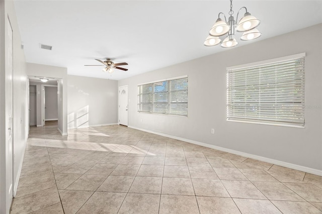 unfurnished room featuring light tile patterned floors and ceiling fan with notable chandelier