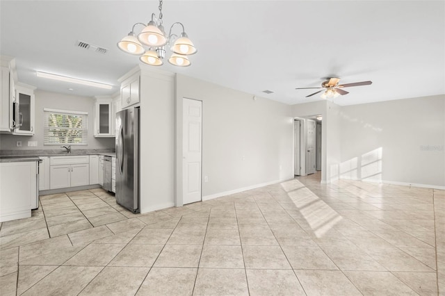 kitchen featuring white cabinets, decorative light fixtures, light tile patterned floors, ceiling fan with notable chandelier, and appliances with stainless steel finishes