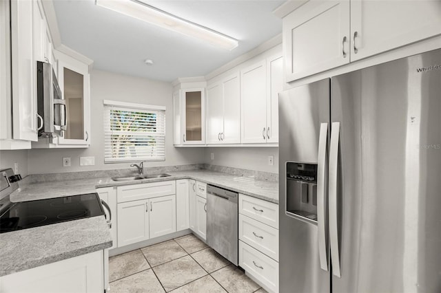 kitchen with light stone counters, sink, white cabinetry, and stainless steel appliances