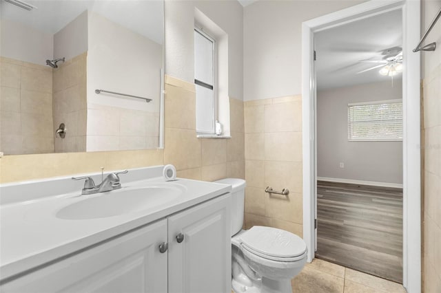 bathroom with hardwood / wood-style floors, vanity, ceiling fan, toilet, and tile walls