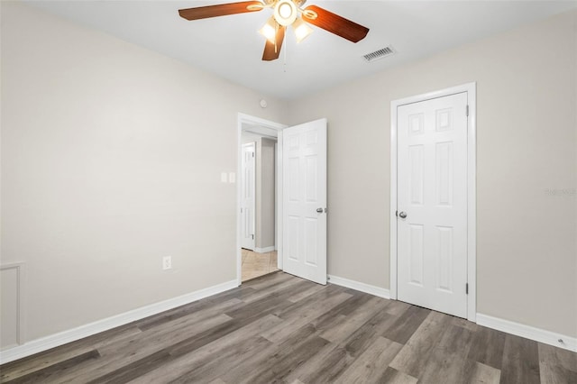 unfurnished bedroom featuring dark hardwood / wood-style flooring and ceiling fan