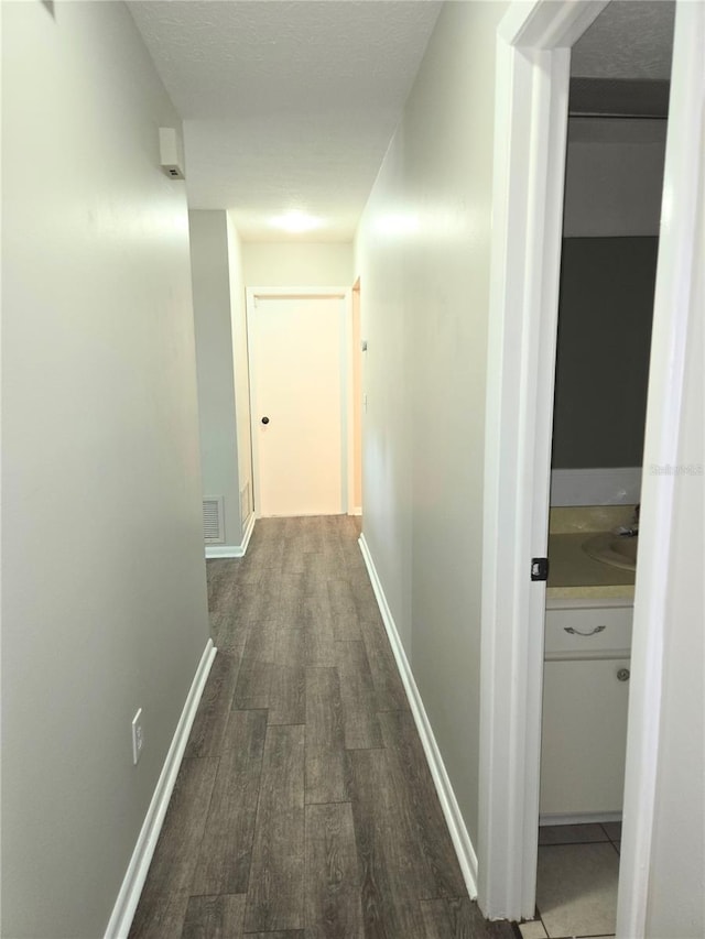 corridor with dark hardwood / wood-style flooring