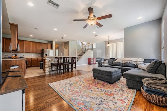 living room with light hardwood / wood-style floors and ceiling fan