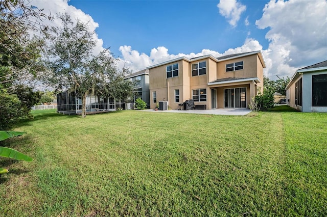 back of house featuring cooling unit, a lawn, and a patio area