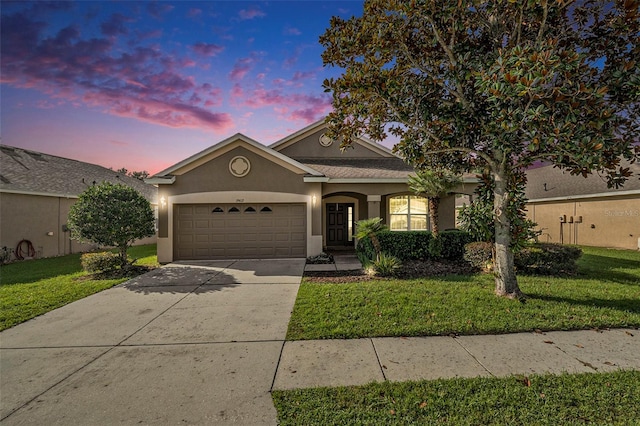 view of front of property with a garage and a yard