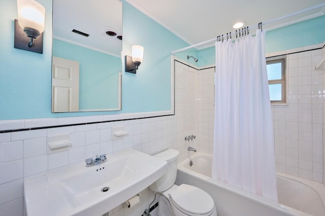 full bathroom featuring sink, tile walls, ornamental molding, toilet, and shower / bathtub combination with curtain