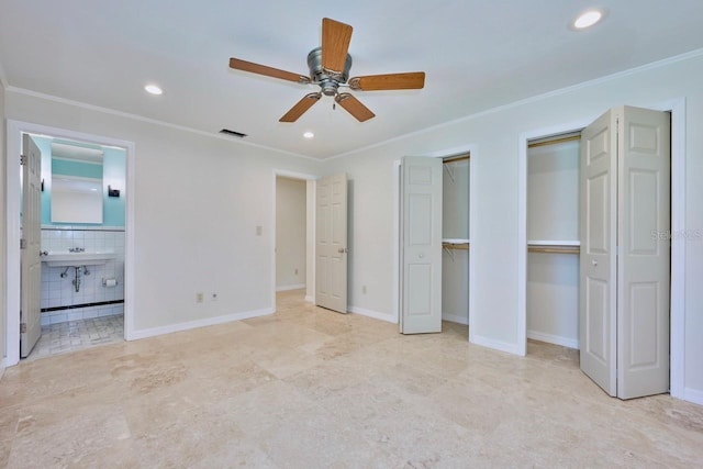 unfurnished bedroom with ensuite bathroom, sink, ornamental molding, two closets, and ceiling fan