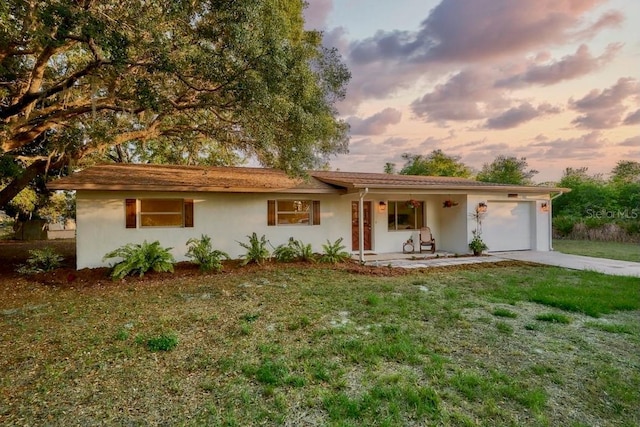 ranch-style house with a yard and a garage