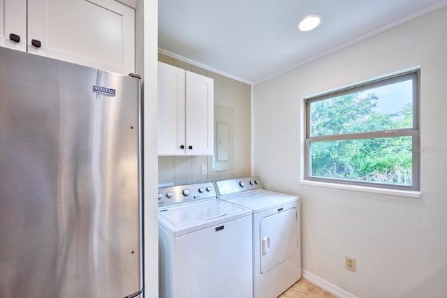 clothes washing area featuring baseboards, cabinet space, crown molding, and washer and clothes dryer